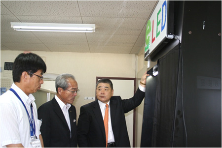 市長に蛍光灯とLEDの消費電力とLuxの相違を実演している写真